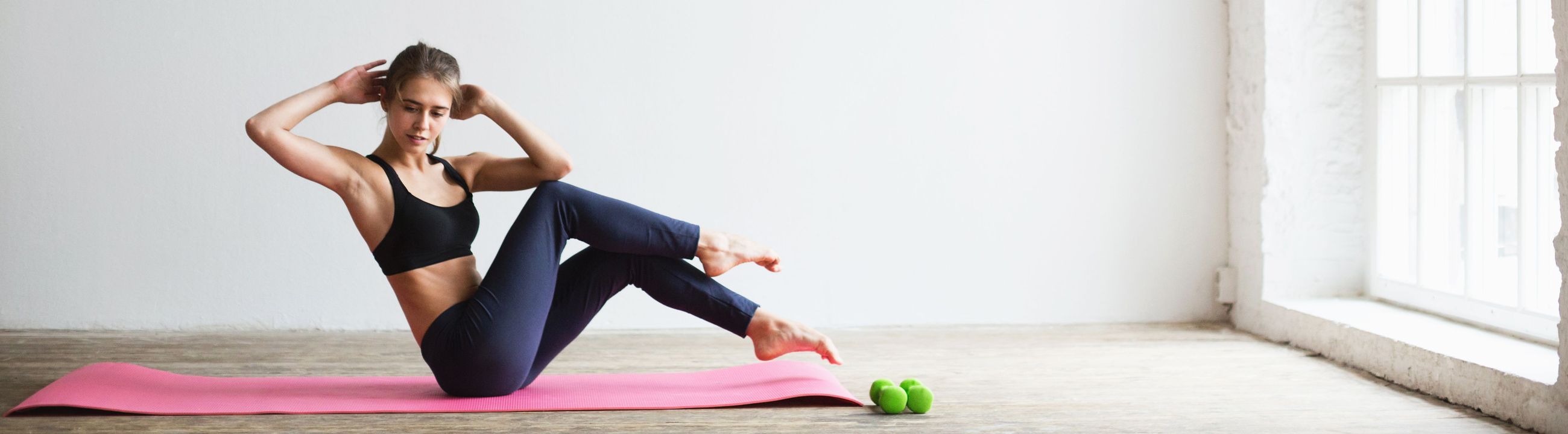 Athletic woman doing butterfly sit-ups on a yoga mat